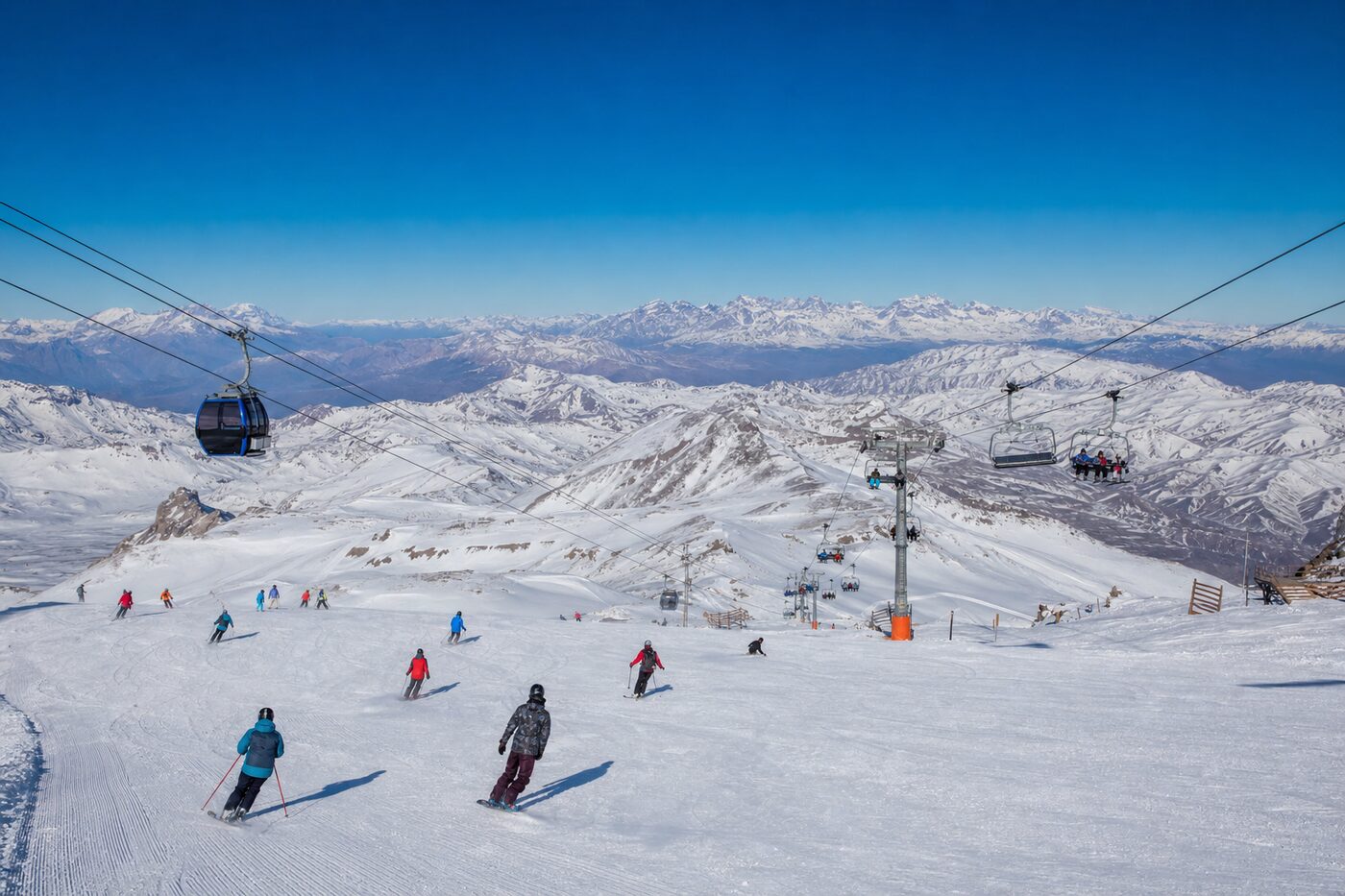 Esquiadores descendo as pistas abertas do Valle Nevado num dia de céu azul nos Andes.