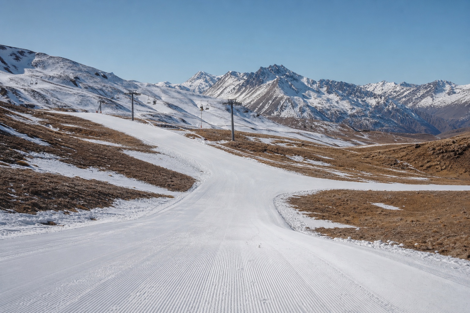 Pista andina no início da temporada, em junho, com faixas de neve rala entre terra e grama